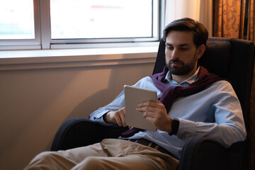 Male guest of a hotel working on a tablet pc