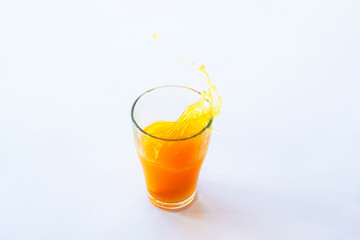 Glass of splashing healthy orange juice isolated on white background