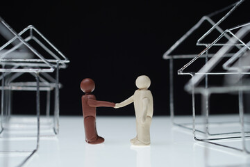 Black man and white man figurines shake hands - 357944717