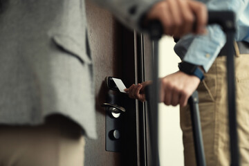 Unknown business travellers opening the hotel room with a keycard