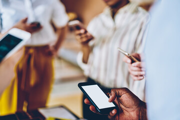 Multiethnic students using smartphones while resting together during break in university