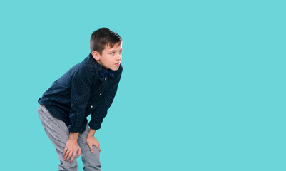 Naklejka premium Happy, smiling boy on a blue background expresses emotions through gestures. Happy childhood concept