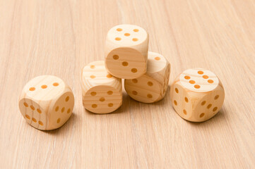 Wooden dice for board game isolated on wooden background. Chance and risk.