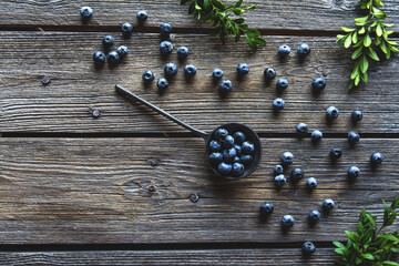 Blueberry in spoon on wooden table background. Blueberries close up. Healthy food, health