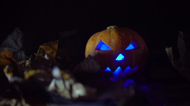 Halloween, pumpkins on the leaves. neon glowing lantern, smoke coming from the side, smoke machine.