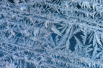 Nice frost pattern on glass in cold temperature colors for summer heat, abstract background
