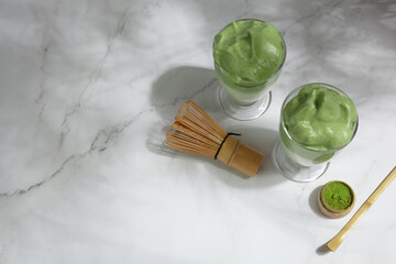 Green matcha dalgona. Trendy hipster drink on marble background.