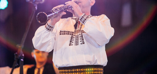 Romanian folkloric traditional person playing clarinet - woodwind instruments 