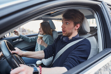 Young couple being scared during car journey