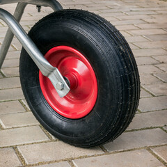 Fototapeta premium Detail of garden wheelbarrow. Wheel with a red disk
