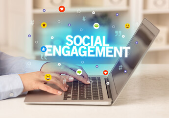 Freelance woman using laptop with SOCIAL ENGAGEMENT inscription, Social media concept