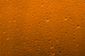 Water drops on glass with vivid medium contrast copper orange color
