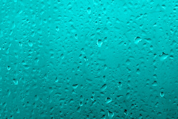 Water drops on glass with vivid medium contrast cyan blue color