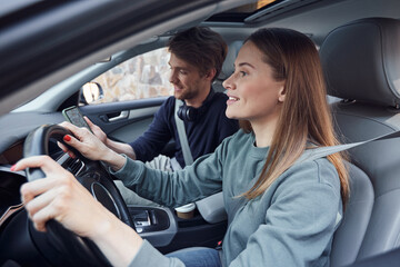 Attentive young woman driving a car with her boyfriend