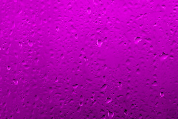 Water drops on glass with vivid medium contrast lilac color