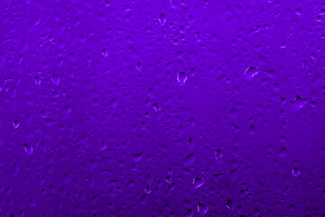 Water drops on glass with vivid medium contrast purplish blue color