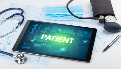 Tablet pc and medical stuff with PATIENT inscription, prevention concept