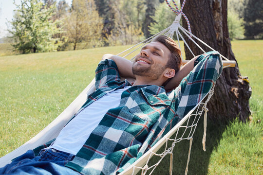 Restful positive man enjoying weekend time in nature