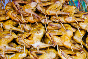 A pile of chicken wings on wood sticks