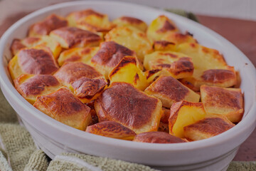 Potato bake in a white oven dish,shot close up and from above.