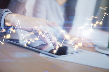 Naklejka premium Double exposure of forex graph drawing and man and woman working together holding and using a mobile device. Trade concept.