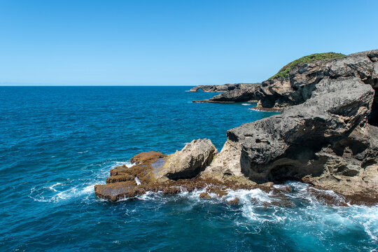 Dramatic cliffs and crashing waves in deep blue waters near Arecibo, Puerto Rico.
