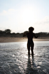 Fototapeta na wymiar girl on the beach backlighting Sun