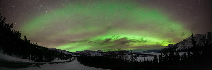 Fototapeta na wymiar Panorama of the aurora borealis, northern lights with stars. Taken in Yukon Territory, north Canada in the winter. 