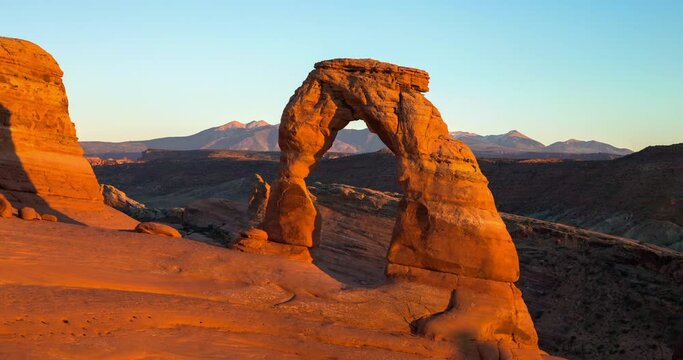 Time lapse shot of people at famous Delicate Arch in desert against sky during sunset - Arches National Park, Utah