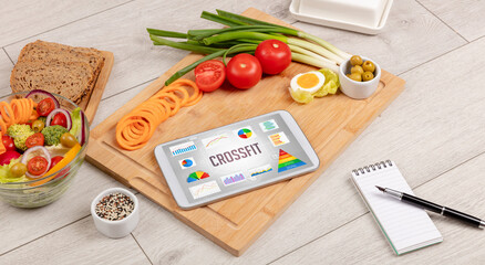 Organic food and tablet pc showing CROSSFIT inscription, healthy nutrition composition