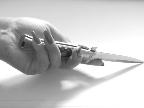 woman's hand and knife switchblade