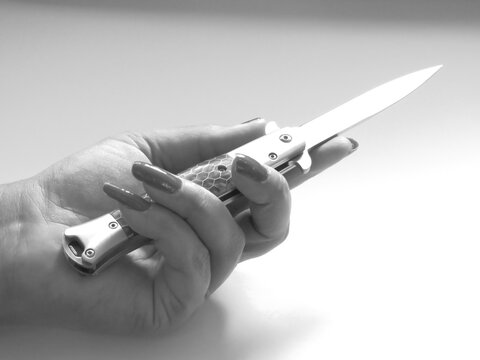 woman's hand and knife switchblade