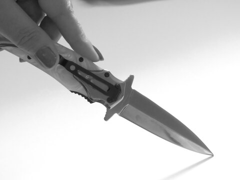 woman's hand and knife switchblade