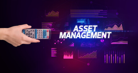 hand holding wireless peripheral with ASSET MANAGEMENT inscription, cyber business concept