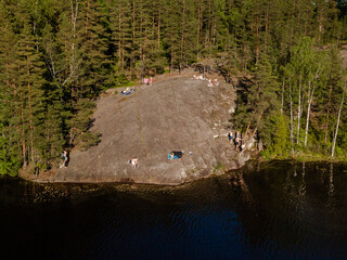 Photo from the air. Forest, rock, lake.
People relax in the summer on the lakes of Finland.