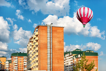 New high-rise buildings with a hot air baloon under blue cloudy sky. Urban view.