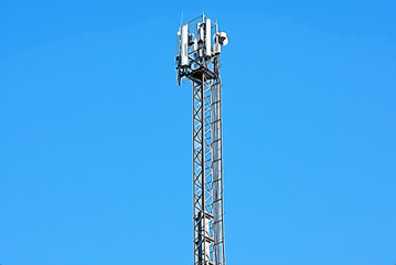 Cellular antenna tower on background of blue sky.