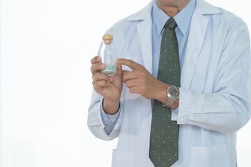 Doctor hand holding a medicine bottle for test in lab or laboratory isolated on white background to...