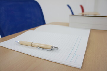 a mechanical pencil, a notebook and a book on the desk
