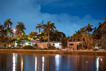 Fototapeta na wymiar Night photo waterfront houses with palm trees