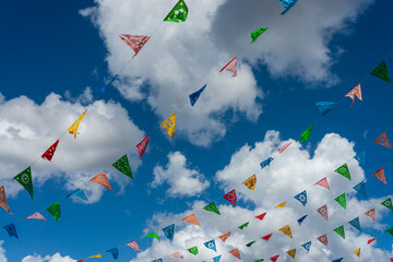Banderillas mexicanas de fiesta contra cielo azul con nubes.