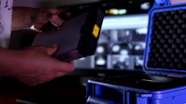 Male hands open small blue high security level bulletproof case and take technical device out with camera background