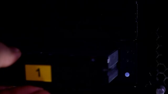 Man hand putting in taking out security video tape hard disk drive in recorder player, close up changing auto focus view