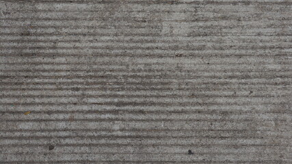 The road that is covered with cement that is long scratched.