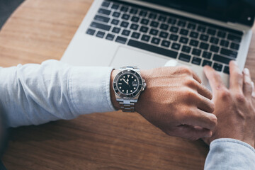 fashionable wearing stylish looking at luxury watch on hand check the time at workplace.concept for managing time organization working,punctuality,appointment - obrazy, fototapety, plakaty