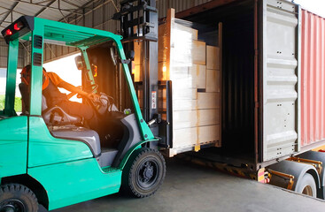 Forklift Tractor Loading Packaging Boxes on Pallets into Shipping Container at Dock Warehouse....