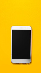 Mobile phone with blank screen on the vivid yellow background