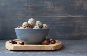 Energy balls of nuts and dates with sesame seeds in a gray bowl. Proper and tasty nutrition