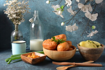 Tasty breakfast rustic style. Stuffed Buns (Pirozhki) ,milk,with green onions and Homemade pickled honey agarics mushrooms,and potatoes. Flowers at background - obrazy, fototapety, plakaty