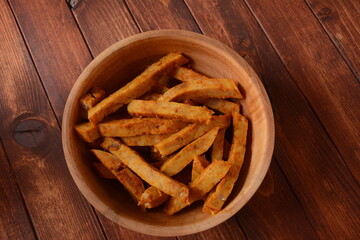 Pieces of fried spiced turkey in a wooden bowl. Rustic style